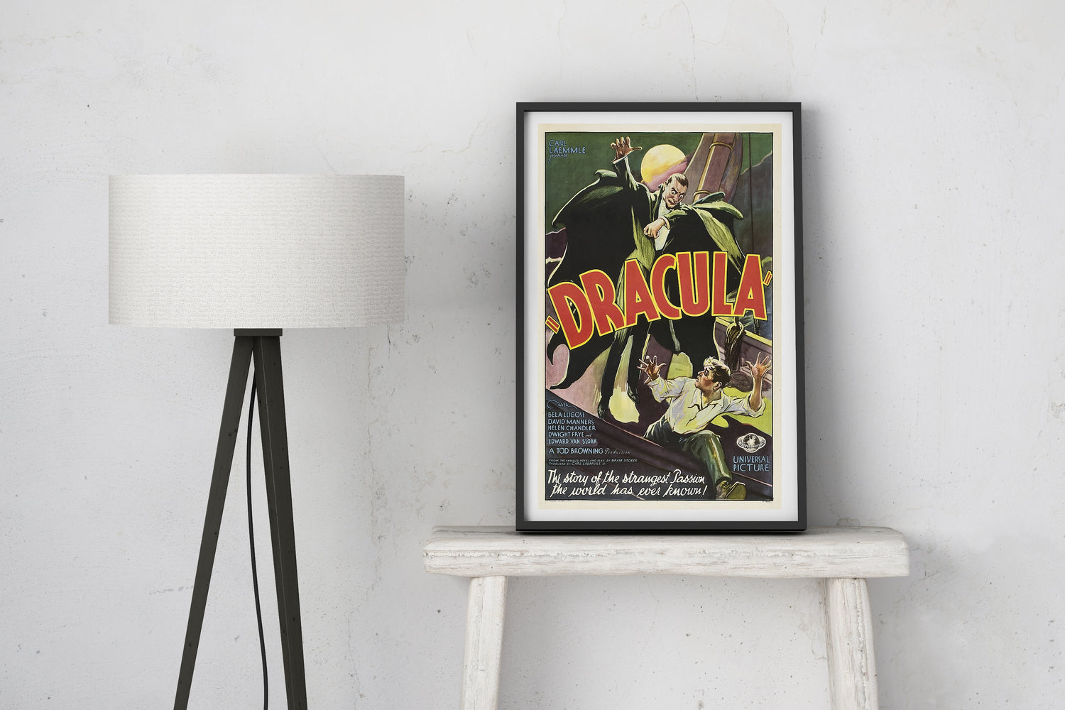 'Dracula' movie poster on a white wall with a lamp in the background