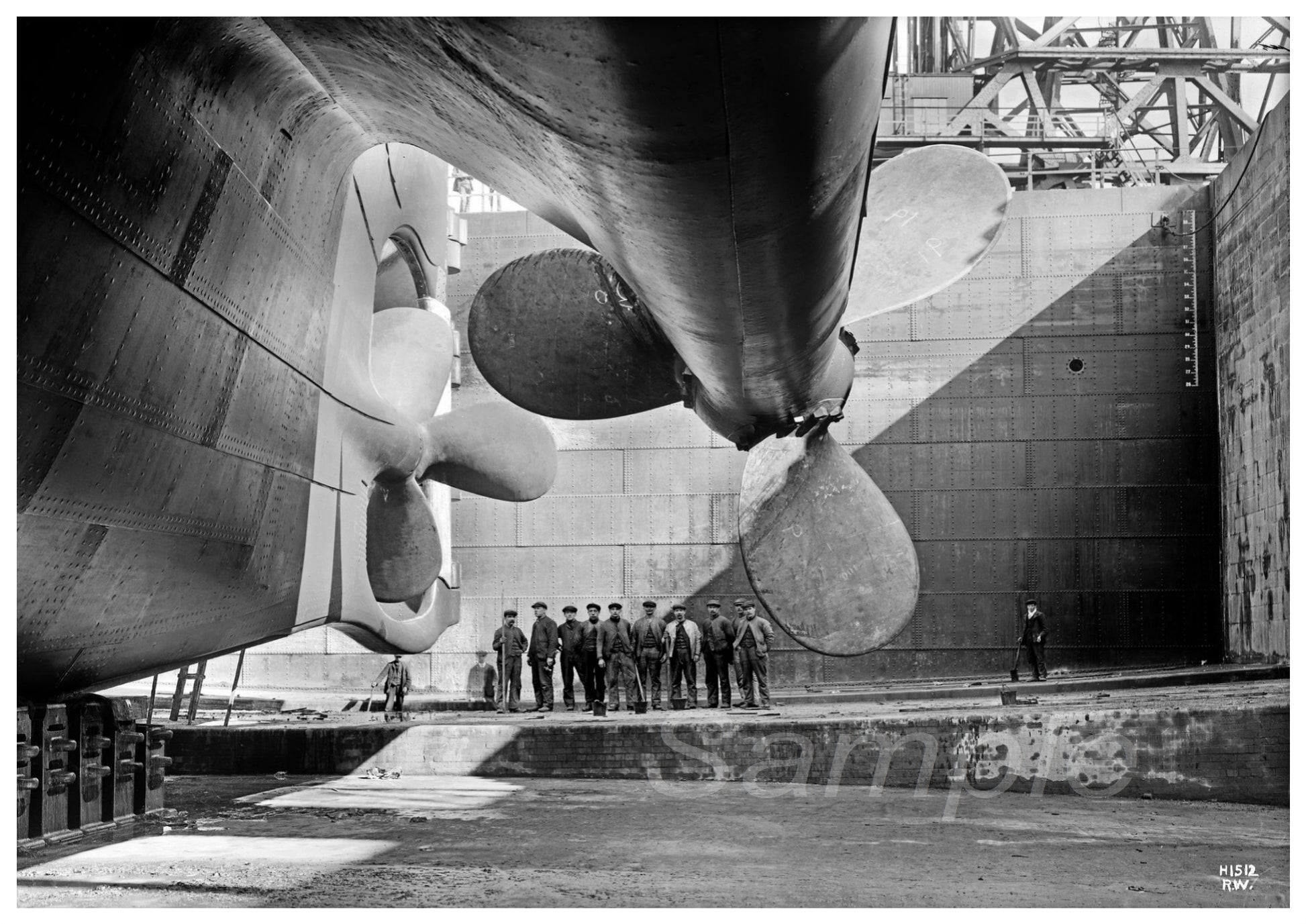 Black and white vintage poster of RMS Titanic propellers, showing the ship's propellers in a drydock with people standing on the deck below.